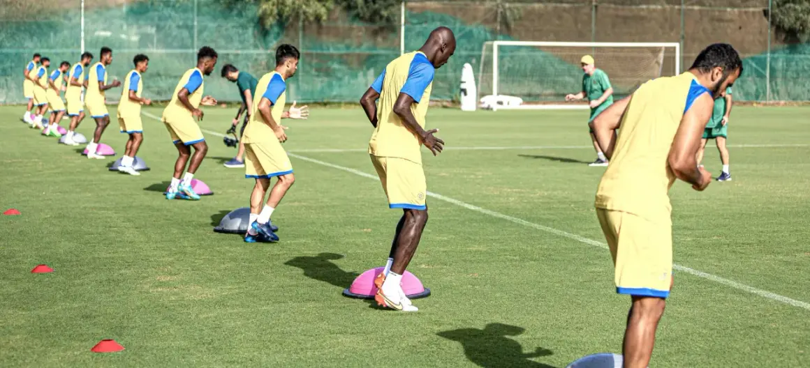 Jugadores de fútbol en pretemporada entrenan equilibrio sobre bosus.