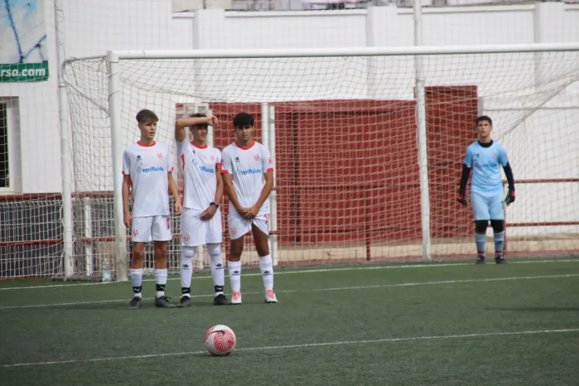 Jugadores del cd cabecense esperan un tiro libre frente a la portería. El portero se prepara.