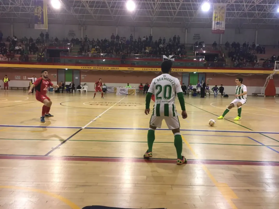 Jugadores de fútbol sala en un partido. Uno con el dorsal 20, R. Bermusell, y otro con el 14. El tacon Villarrobledo resuena en la cancha.