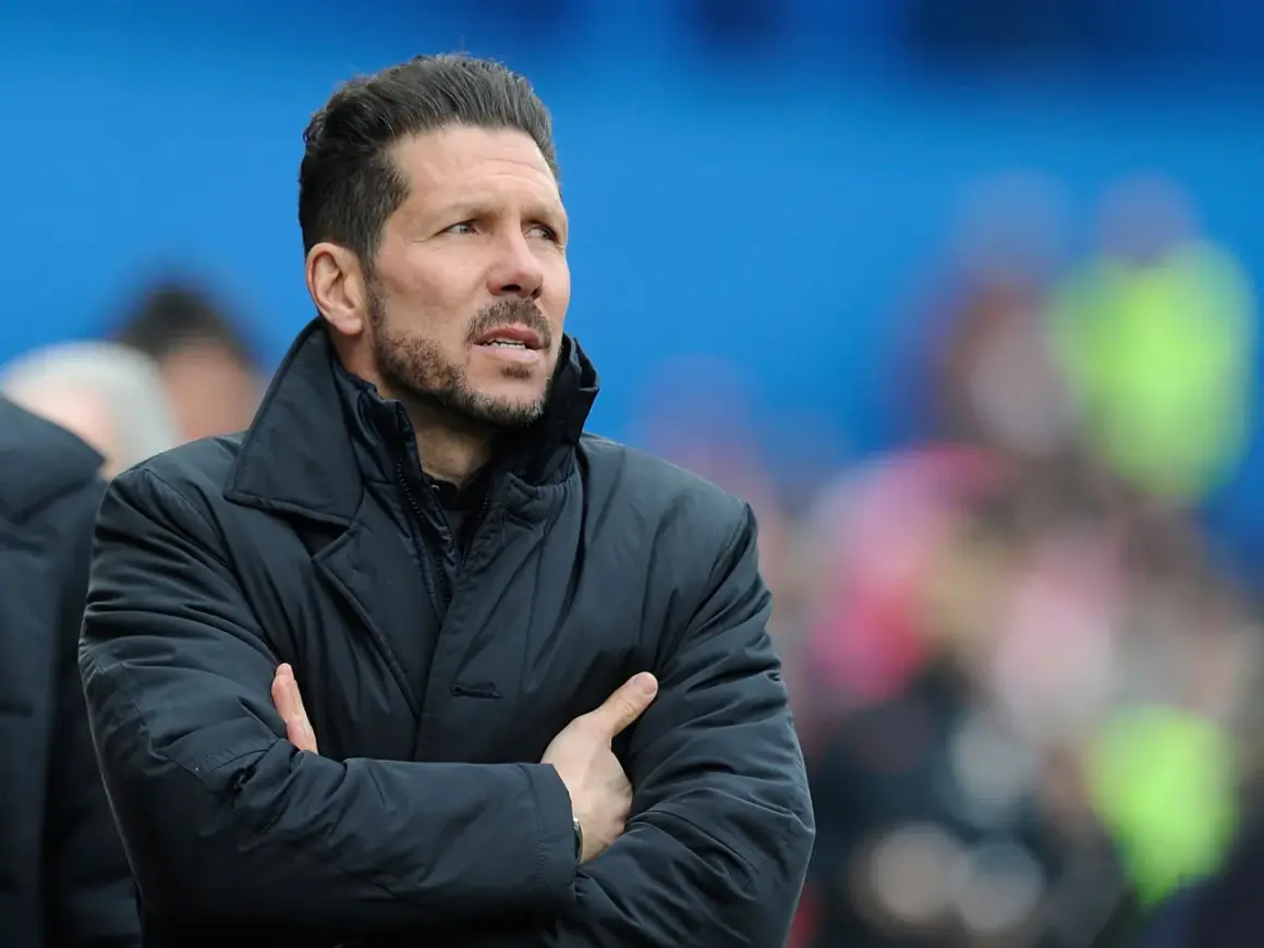 Diego Pablo Simeone, con los brazos cruzados, mira atentamente el partido con una chaqueta oscura.