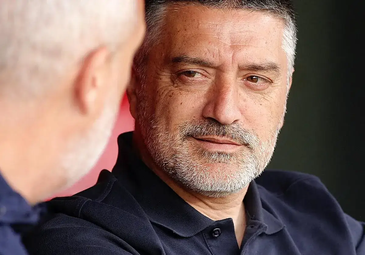 Primer plano de un entrenador del Sevilla, con barba canosa y mirada pensativa.