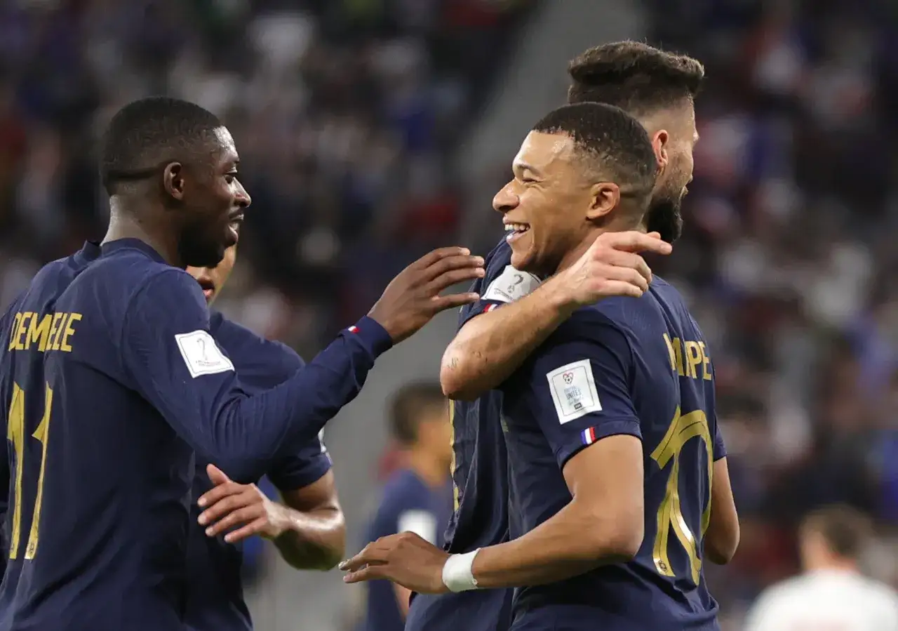 Jugadores de Francia celebran un gol contra Polonia. Mbapp&eacute; sonr&iacute;e mientras Demb&eacute;l&eacute; le da la mano.