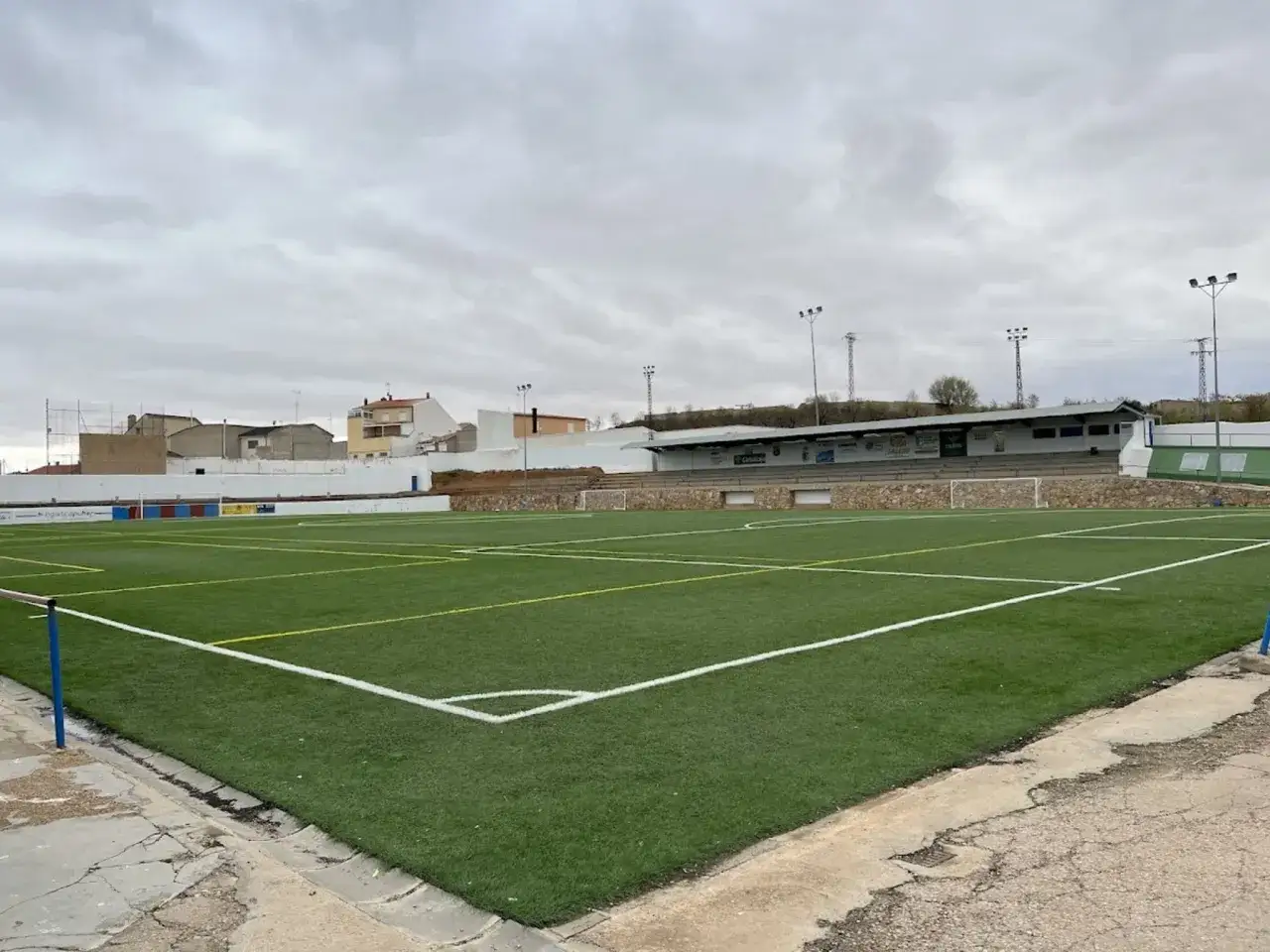 Campo de fútbol de césped artificial con gradas y edificios al fondo. El San Clemente CF entrena aquí.