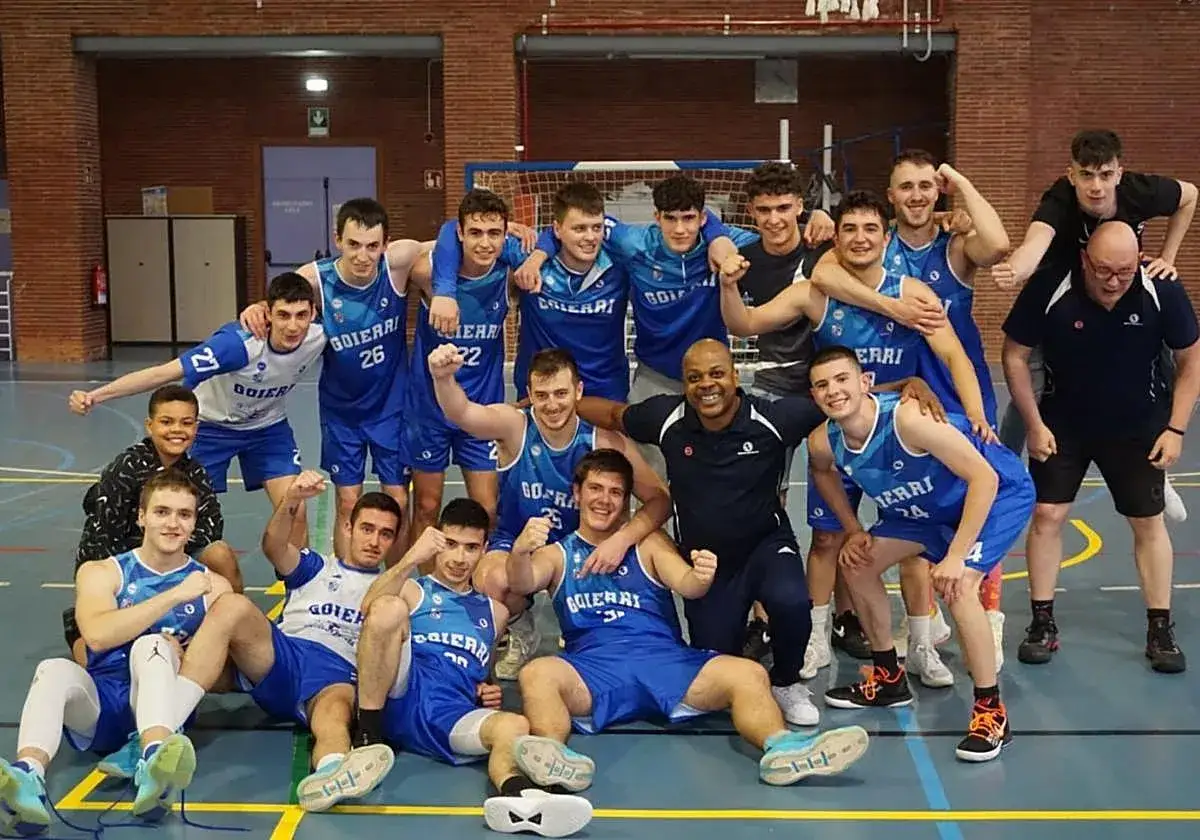 El equipo de Goierri saskibaloia celebra una victoria en la cancha. Los jugadores, con sus uniformes azules, posan sonrientes y orgullosos.