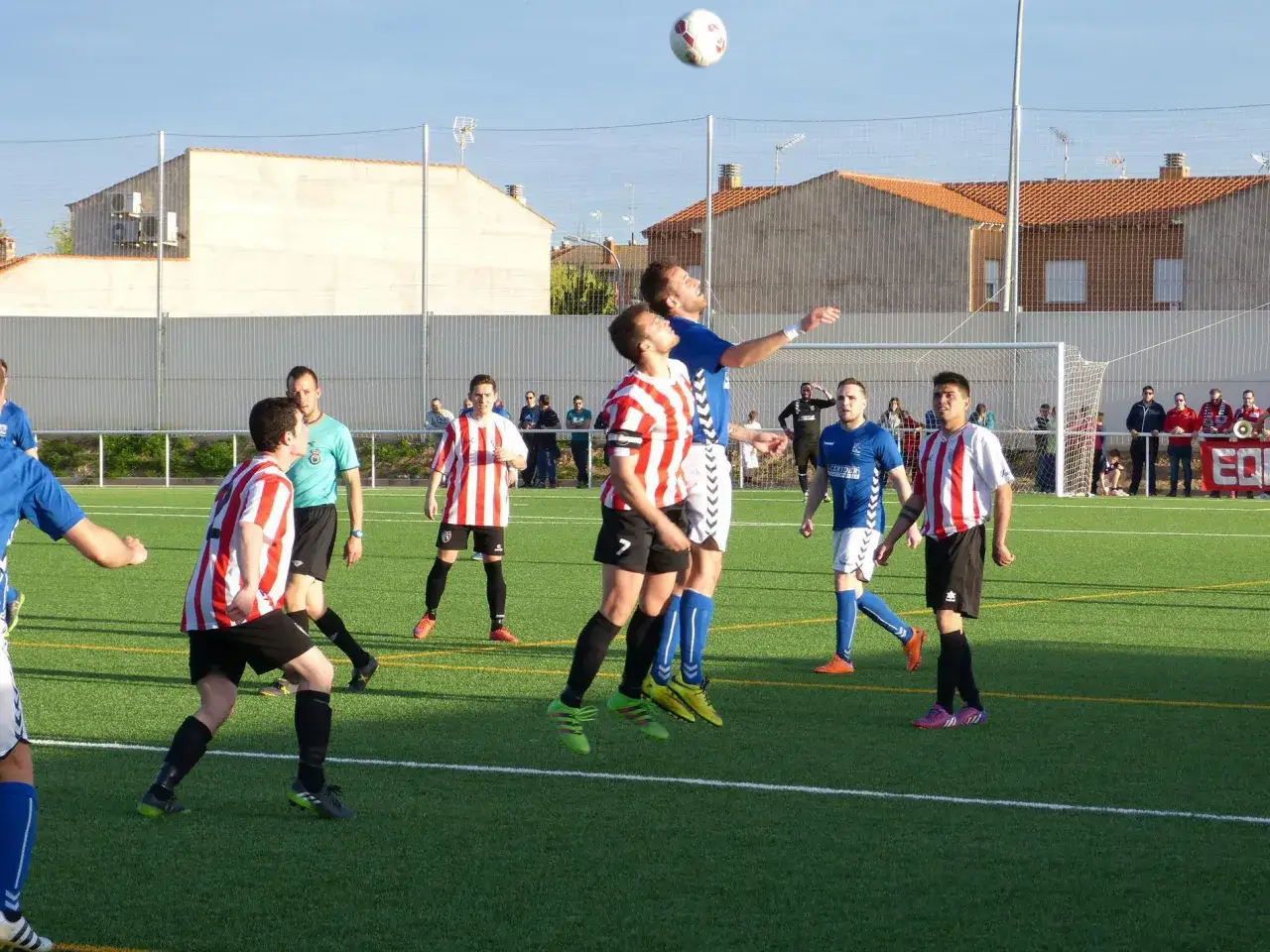 Jugadores de Yepes CF saltan a por el balón en un partido de fútbol.