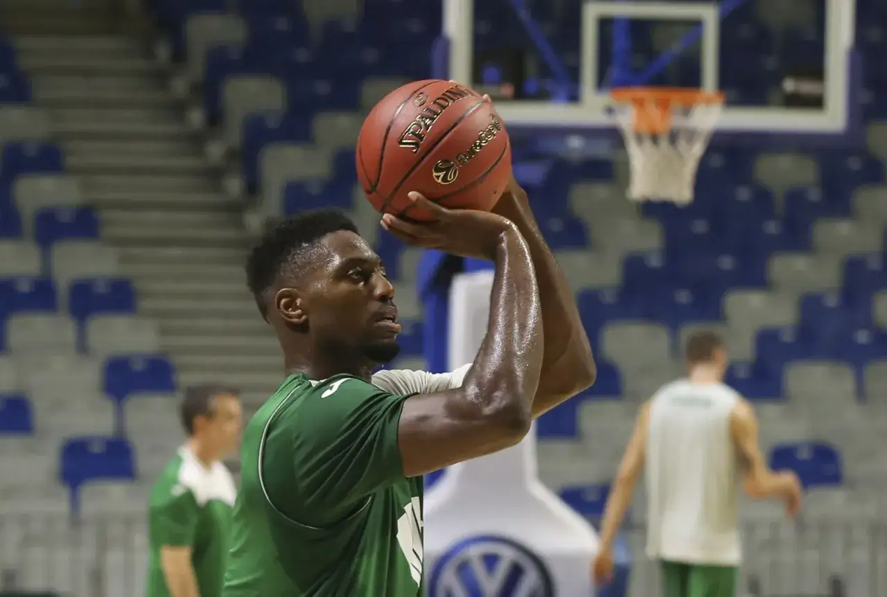 Jugador de baloncesto concentrado, listo para lanzar un triple.