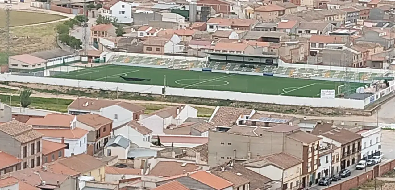 Campo de f&uacute;tbol del Atl&eacute;tico Consuegra, con gradas y edificios residenciales alrededor.