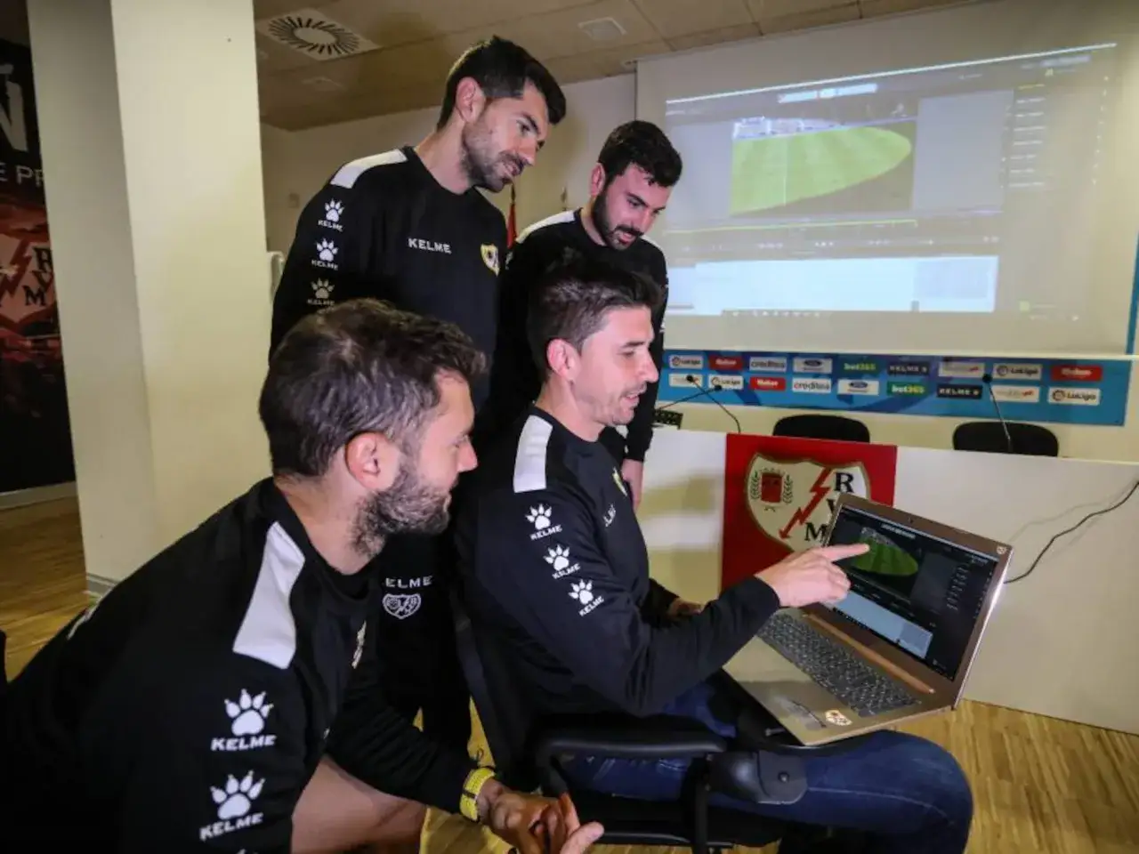 Entrenadores analizan jugadas en pantalla. El trabajo en equipo es clave para ser los mejores entrenadores actuales.