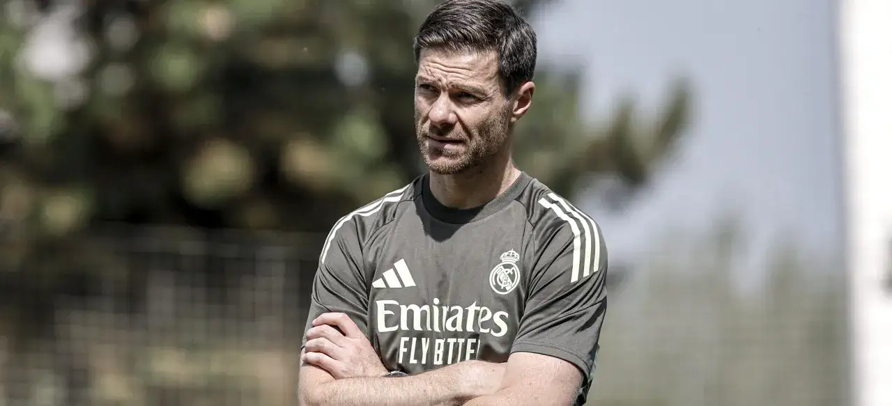 El entrenador del Real Madrid, con los brazos cruzados, mira pensativo.