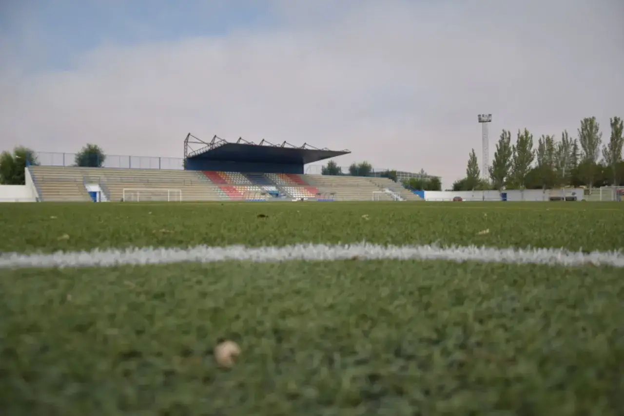Campo de fútbol del CD Urda, con gradas vacías y césped artificial.
