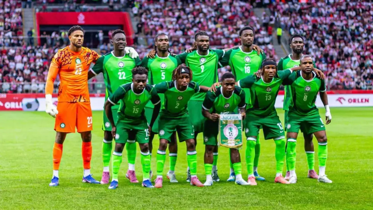 El equipo de selección Nigeria posa en el campo, con el portero de naranja y el resto de verde.