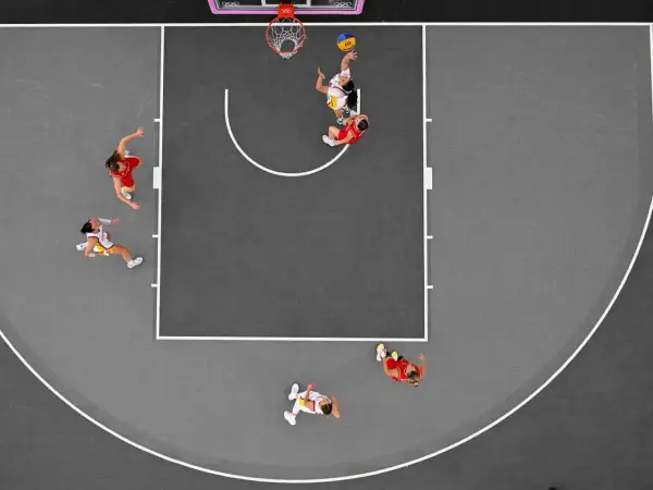 Jugadoras en acción durante un partido de baloncesto 3×3. Una lanza al aro, otra defiende.