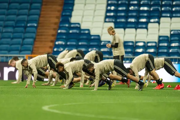 Jugadores de fútbol en posición de plancha durante el calentamiento.