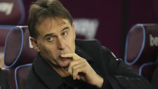 Entrenador de Qatar, con la mano en la barbilla, pensativo, sentado en un banco.