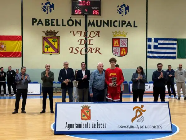 Joven jugador de baloncesto recibe trofeo en el Pabellón Municipal de Íscar.