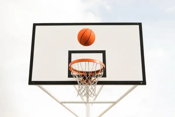 Balón de baloncesto naranja en el aire, a punto de entrar en la canasta. ¡Un tiro perfecto!