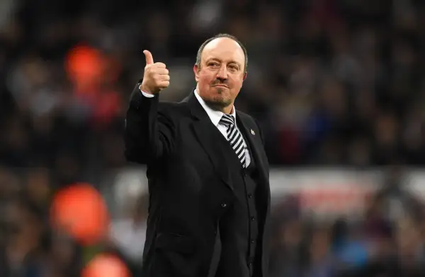 Rafa Benítez, con traje y corbata a rayas, da el pulgar hacia arriba. Su trayectoria con diversos equipos es legendaria.