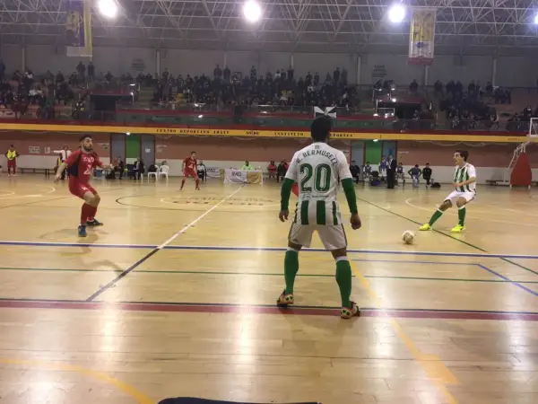 Jugadores de fútbol sala en un partido. Uno con el dorsal 20, R. Bermusell, y otro con el 14. El tacon Villarrobledo resuena en la cancha.
