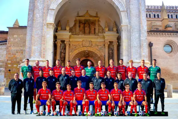 El equipo del Atlético Tarazona posa para una foto grupal frente a una fachada histórica.