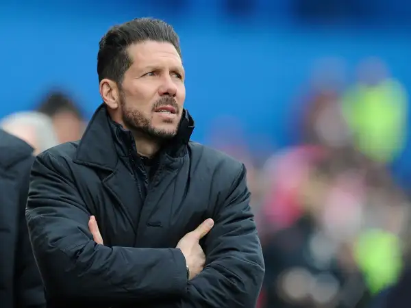 Diego Pablo Simeone, con los brazos cruzados, mira atentamente el partido con una chaqueta oscura.
