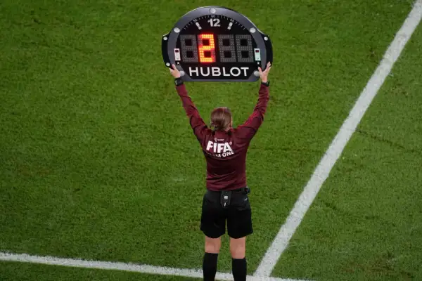 Árbitro muestra el tablero con el número 8, indicando un cambio o el tiempo de descanso en el futbol.