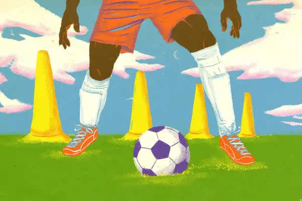 Jugador de fútbol en entrenamiento, rodeado de conos amarillos y un balón morado y blanco.