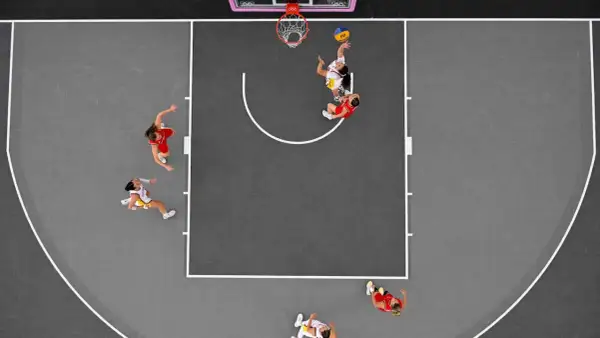 Jugadoras de baloncesto 3x3 compiten en la cancha. Se aprecian diferentes tipos de baloncesto en acción, con una lanzando a canasta.