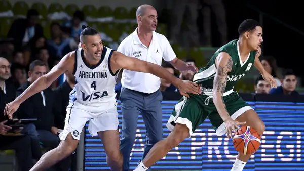 Jugadores de baloncesto argentinos en acción. El número 4 de Argentina intenta robar el balón a un oponente.